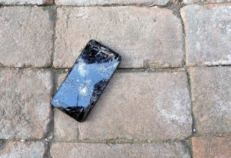 celular no chão com tela quebrada